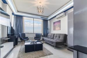 宿务Avenir Condo for rent near IT Park Cebu with FREE Netflix, 49-inch Samsung Curve TV的客厅配有沙发和两把椅子
