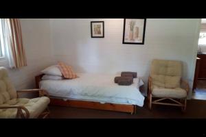 克尼斯纳Woodbourne Resort的一间卧室配有一张床、一把椅子和一张沙发