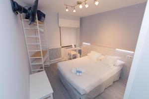 索里亚维也纳旅舍的小房间设有白色的床和梯子