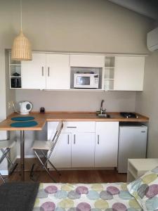 拉帕洛马爱德华公寓的厨房配有白色橱柜和带微波炉的桌子。