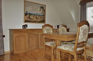 比斯平根Ferienwohnung Kiefernblick-Wedemann的一间带木桌和椅子的用餐室