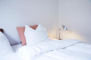 奥胡斯Amaliegade 10 B的床上的2个白色枕头和灯