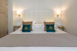 内尔哈Hostal Boutique Plaza Cantarero的一间卧室配有一张带蓝色枕头的床