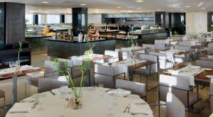 阿德耶格兰帝纳菲H10酒店 - 仅限成人的一间设有白色桌椅的餐厅和一间酒吧