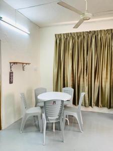巴特沃思Abbie's Homestay Butterworth Penang的配有吊扇的客房内的桌椅