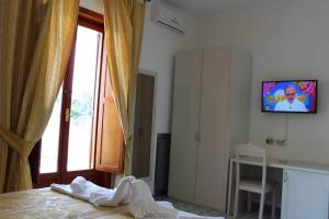 伊斯基亚伯斯柯酒店的一间卧室设有一张床、一台电视和一个窗口。