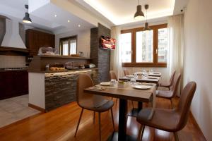 罗马J24住宿加早餐旅馆的厨房以及带木桌和椅子的用餐室。