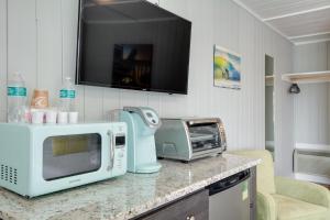 斩魔山See Sea Motel的带微波炉的厨房台面和电视。
