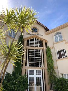 Lance aux ÉpinesMandela Court Suites Grenada的前面有棕榈树的建筑