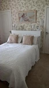 基尔温宁内泽曼斯旅馆的卧室配有一张白色床,墙上挂着一幅画