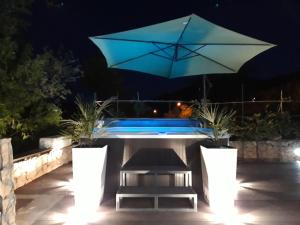 兹曼Villa Aurelia的庭院设有带遮阳伞的桌子和游泳池。