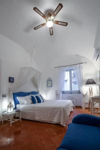 阿特拉尼Vicolo 23 House的一间卧室配有一张带吊扇的床