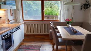 罗孚尔Ferienwohnungen Schweinöster的一间带桌子的厨房和一间带窗户的用餐室