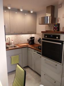 卢布林Bruxapart的厨房配有白色橱柜、水槽和烤箱。