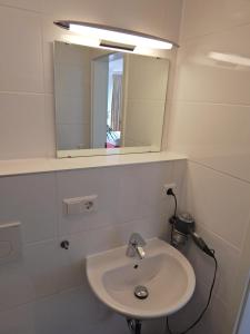 罗伊特林根FREE Apartment - Bei der Markthalle的白色的浴室设有水槽和镜子