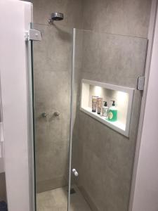 里约热内卢DeROSE Ipanema - quarto no coração de Ipanema的带淋浴的浴室和玻璃门