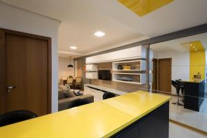 维拉维尔哈FRENTE MAR: Lindo Ap - aconchegante e decorado em Vila Velha的一个带黄色柜台的厨房和一间客厅