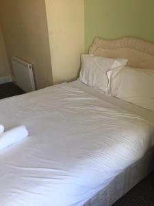 克莱克西顿Gateway Lodge的一张带白色床单和枕头的床