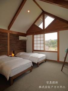 KasaokaShiraishi Island International Villa的带窗户的客房内的两张床