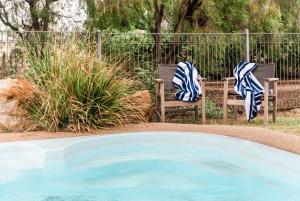 朗里奇盐林山林小屋的两把椅子和毛巾,位于游泳池旁