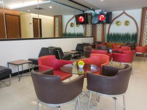 当格浪d'primahotel Airport 1的一间设有红色椅子和桌子的等候室
