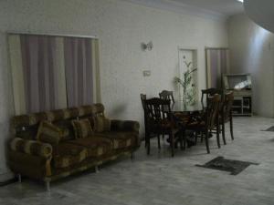 木尔坦Sunrise Guest House Multan的客厅配有沙发和桌椅