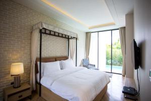 Nong Sarai独特收藏西维莱山私人泳池别墅的一间卧室设有一张床和一个大窗户