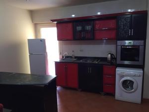 艾因苏赫纳Chalets in Porto Sokhna - Pyramids - Families Only的一间厨房,配有红色橱柜和一台洗衣机