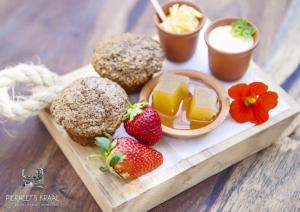 比勒陀利亚Pierneef's Kraal的一张桌子上装有松饼和草莓的托盘