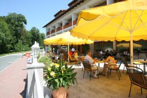 巴特塔茨曼斯多夫Hotel zum Kastell的一群人坐在餐厅里,被黄伞包围