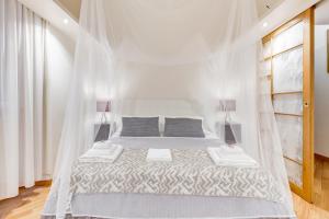 罗马VENETO COMFORTABLE Apartment的白色卧室配有带蚊帐的床