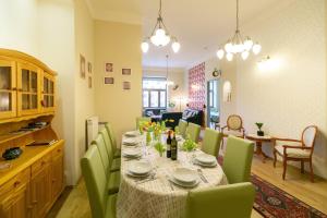 布达佩斯布达朱厄尔公寓的一间带桌子和绿色椅子的用餐室