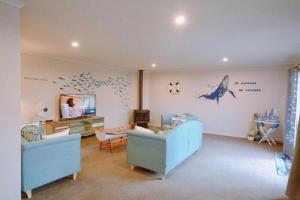 罗托鲁瓦The Ocean Dream的客厅配有蓝色家具,墙上挂有海豚