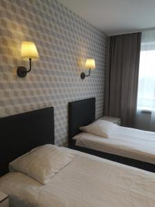 文茨皮尔斯金塔如拉酒店的酒店客房设有两张床和两盏墙上的灯。
