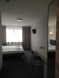 文茨皮尔斯金塔如拉酒店的酒店客房,设有两张床和一张桌子及椅子
