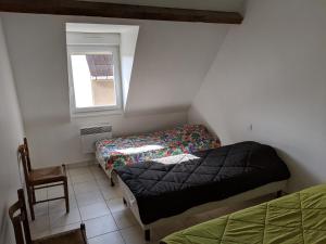 维桑Le gîte de Magaly的小房间设有两张床和窗户
