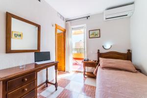 阿尔么丽亚塞维利亚酒店的一间卧室配有一张床和一张带笔记本电脑的书桌