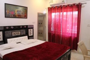 奥拉奇哈日落酒店的一间卧室配有一张带红色窗帘的床