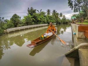 安帕瓦บ้านกรนรา Baan Kornnara的正在河上划船的人