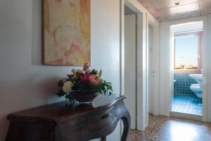 威尼斯罗坎达爱桑蒂阿帕斯托利酒店的浴室设有一张桌子,上面有花瓶