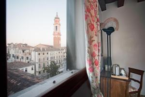 威尼斯罗坎达爱桑蒂阿帕斯托利酒店的享有城市美景的窗户,设有钟楼