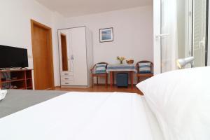 斯拉诺Guest House Franica & Pero Lobrovic的卧室配有一张床和一张桌子及椅子