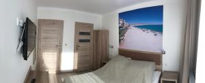 米泽德沃兹Pokoje Gościnne - Port的一间卧室配有一张床,享有海滩美景