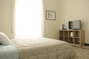 卡塔尼亚Dimora del sole的一间白色卧室,配有床和电视