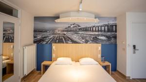 布兰肯贝赫Hotel Paradisio by WP Hotels的一间卧室配有一张带码头图片的床