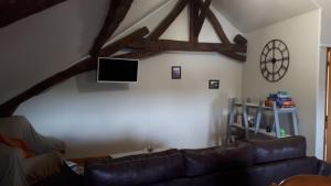 Le Nouvion-en-ThiéracheChambre du Nouvion的客厅配有真皮沙发和电视