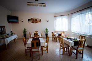 马佐夫舍地区新庄园霍特里克莫德林机场酒店的用餐室设有桌椅和窗户。