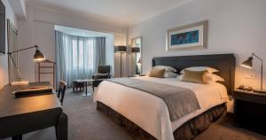 马普托阿凡尼达酒店的酒店客房设有一张大床和一张书桌。
