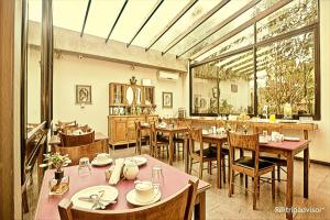 科洛尼亚-德尔萨克拉门托阶地精品酒店的餐厅设有桌椅和大窗户。