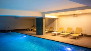 布兰肯贝赫Hotel Aazaert by WP Hotels的一个带椅子和桌子的房间的游泳池
